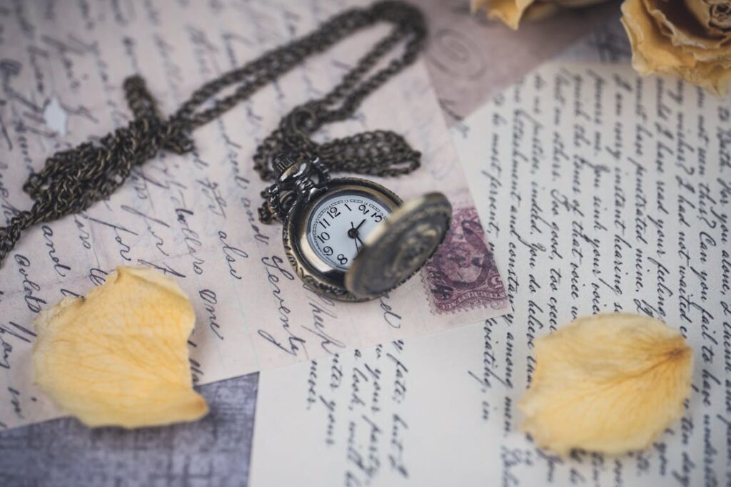 Vintage pocket watch resting on handwritten letters with dried yellow rose petals, symbolizing timeless memories and legacy.